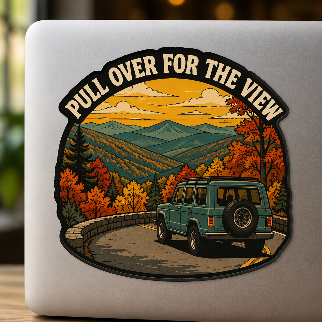 “PULL OVER FOR THE VIEW” appears in bold cream lettering around a screen-print-inspired roadside turnout scene overlooking layered autumn mountain ridges in rust, teal, and golden yellow.